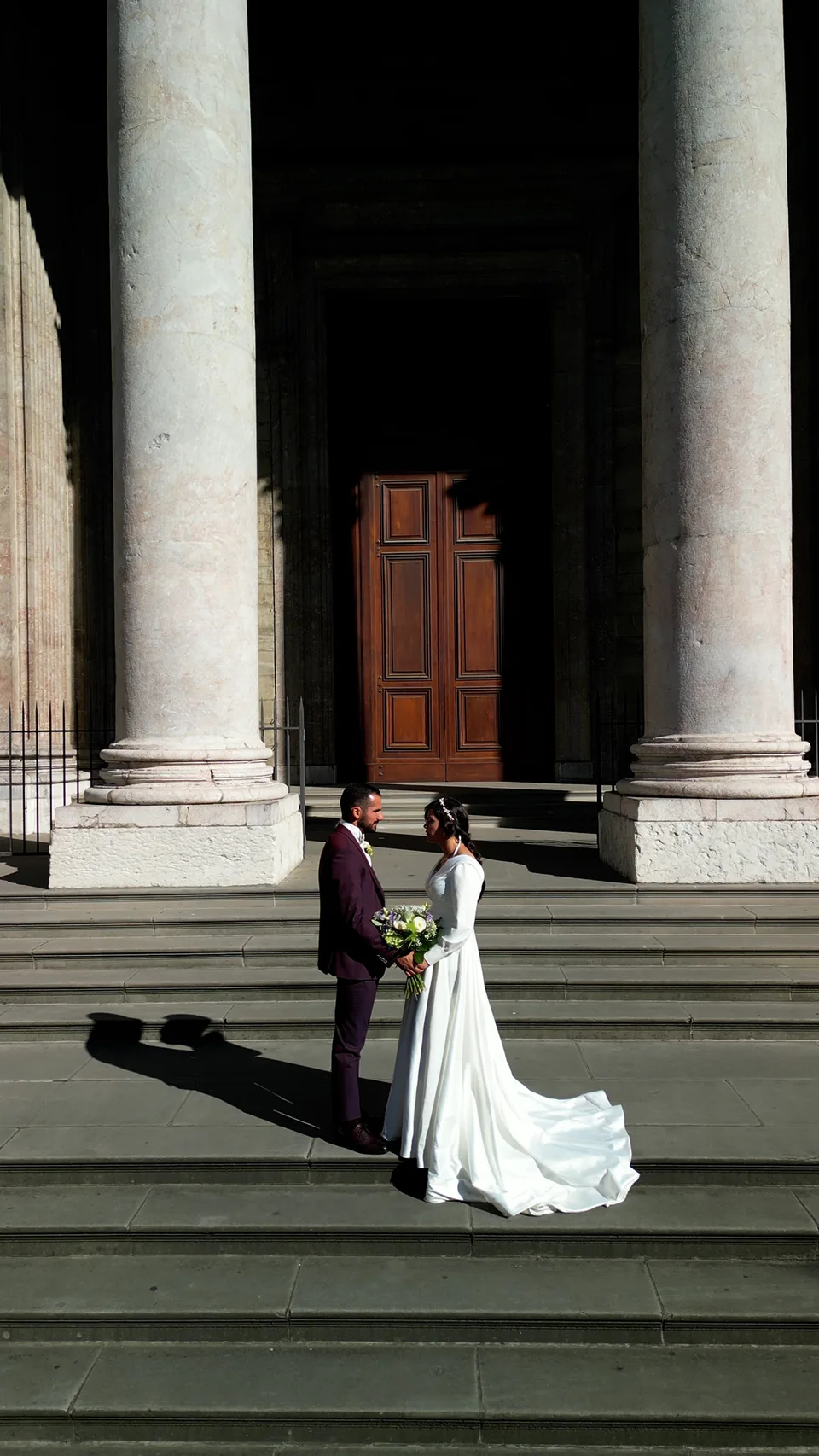 Une mariée au pied de grandes colonnes en pierre