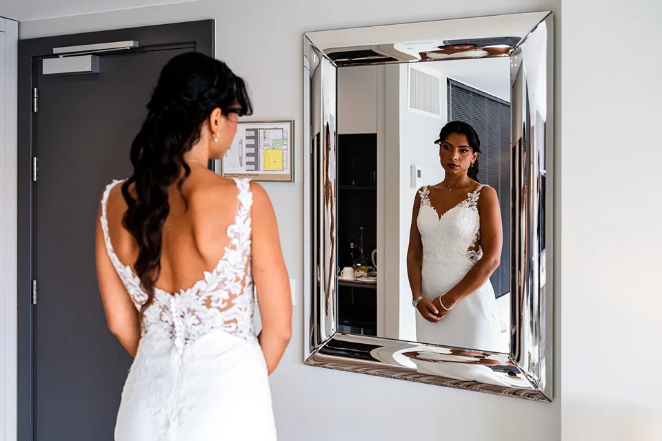 La mariée se regarde dans le miroir pendant les préparatifs