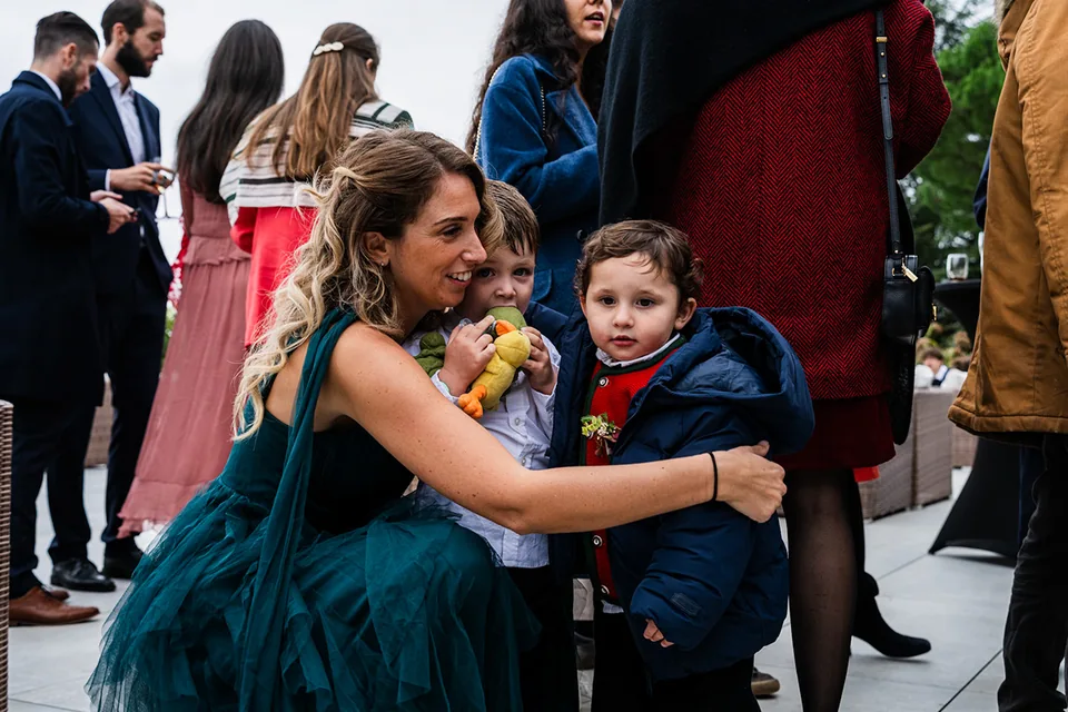 Une invitée souriante porte un enfant parmi les proches