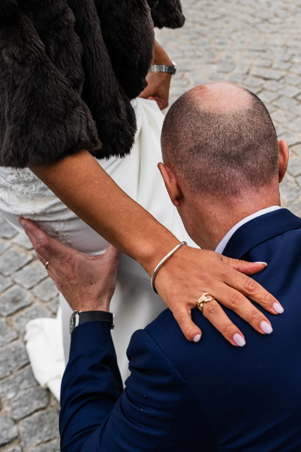 La mariée pose les mains sur le visage de son compagnon